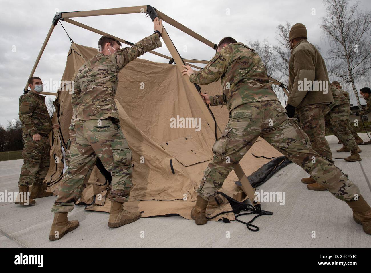 U.S. Air Force participants in the Agile Combat Employment Academy set up a tent during the training on Spangdahlem Air Base, Germany, Feb. 22, 2021. Not only did participants learn different skills during the four-day training, they also taught their own skillsets to other members to promote a highly versatile deployment force. Stock Photo