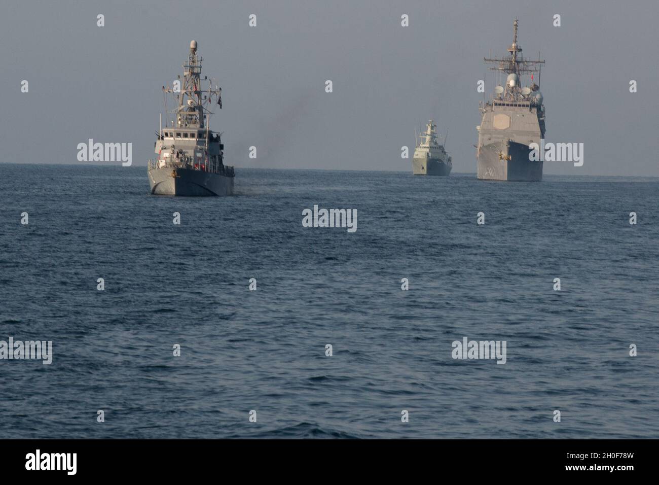 210222-A-BD272-0689 SEA OF OMAN (Feb. 22, 2021) – Patrol coastal ship USS Thunderbolt (PC 12), left, guided-missile cruiser USS Port Royal (CG 73), right, and corvette RNOV Al Rasikh (Q 42)  sail in formation during coalition exercise Khunjar Hadd 26 in the Sea of Oman, Feb. 22. Khunjar Hadd 26 is an annual exercise meant to enhance mutual maritime capabilities and interoperability between the U.S., Omani, French and United Kingdom military forces in order to address threats to freedom of navigation and the free flow of international commerce. Stock Photo