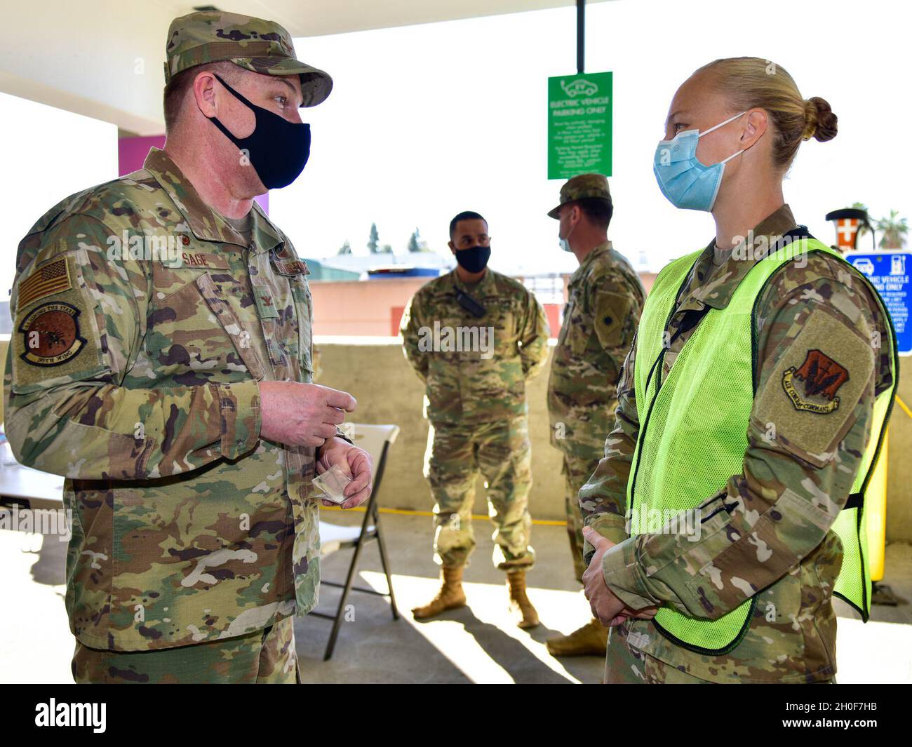 U.S. Air Force Col. Robert Sage, left, commander of the 195th Wing, California Air National Guard, awards his coin to Senior Airman Sarah Hudson, 163d Maintenance Squadron, 163d Attack Wing, California National Guard, at the COVID-19 community vaccination center on the Cal; State Los Angeles,, Feb. 23, 2021. Hudson was recognized for her efforts in support of the drive-thru vaccination site of the center. Stock Photo