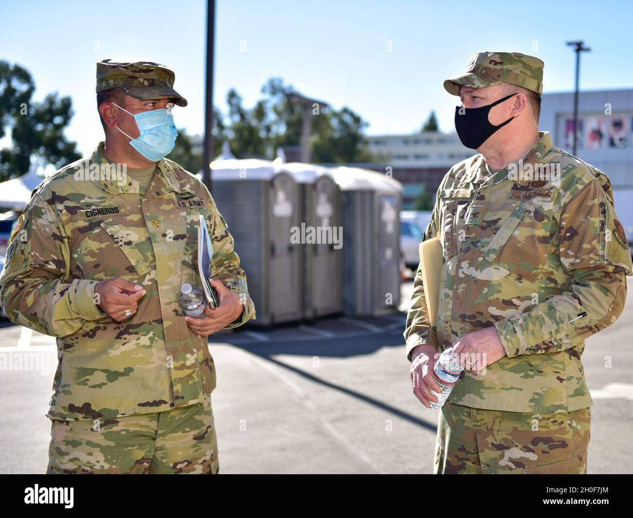 U.S. Air Force Col. Robert Sage, right, commander of the 195th Wing, California National Guard, speaks with U.S. Army Maj. Leroy Cisneros, commander of Joint Task Force Mustang, California National Guard, speak in front of the drive-thru site of the COVID-19 community vaccination center at Cal State Los Angeles, Feb. 23, 2021. Over 30 Airmen from the wing have been activated as part of the joint force to provide administrative support to the vaccination efforts. Stock Photo