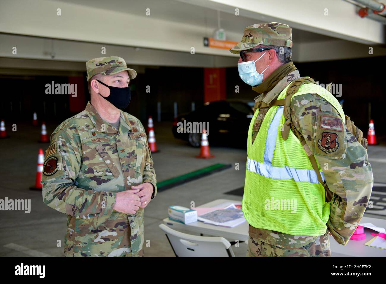 U.S. Air Force Col. Robert Sage, left, commander of the 195th Wing, California National Guard, awards his coin to Staff Sgt. Lera Masini, 195th Operations Group, 195th Wing, at the COVID-19 community vaccination center at Cal State Los Angeles, Feb. 23, 2021. Masini was recognized for her efforts in support of the drive-thru vaccination site of the center. Stock Photo