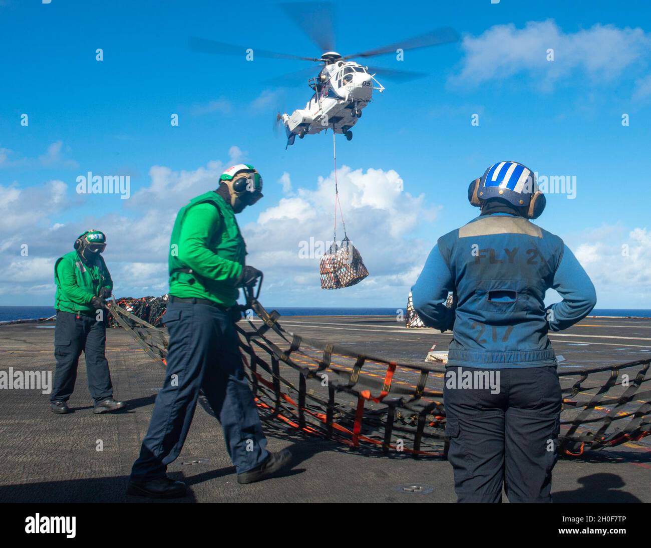 PACIFIC OCEAN (Feb. 23, 2021) U.S. Sailors stow cargo nets aboard the aircraft carrier USS