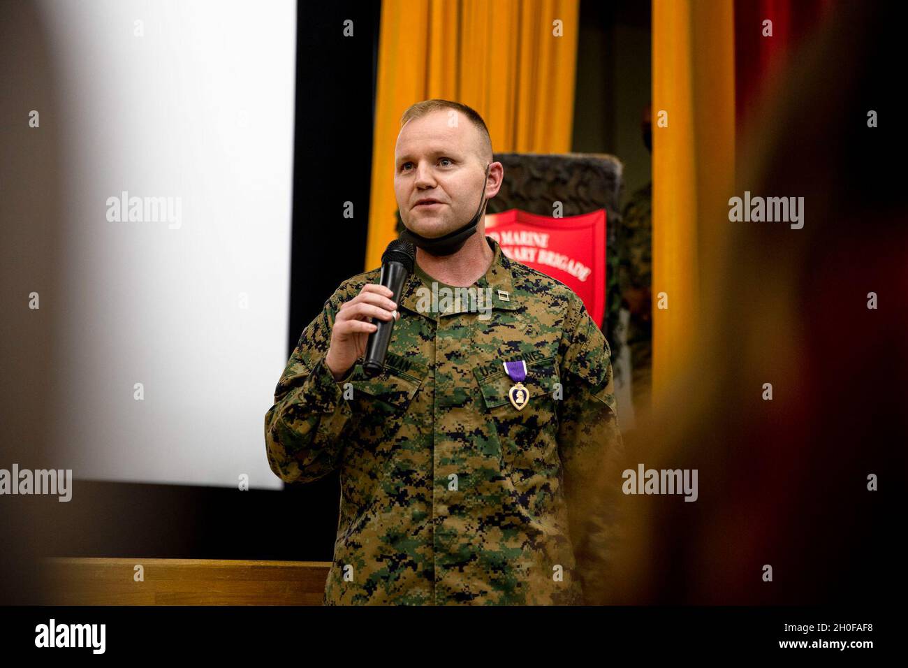 U.S. Marine Corps Capt. Kevin. W. Leishman, an Anti-Terrorism force protection officer, 3rd Marine Expeditionary Brigade, addresses the audience during a Purple Heart ceremony at the base theater, Camp Courtney, Okinawa, Japan, Feb. 24, 2021. During the ceremony Leishman was awarded for wounds sustained in action against enemies of the United States 16 years ago during the Battle of Fallujah, Operation Phantom Fury, Operation Iraqi Freedom. Stock Photo
