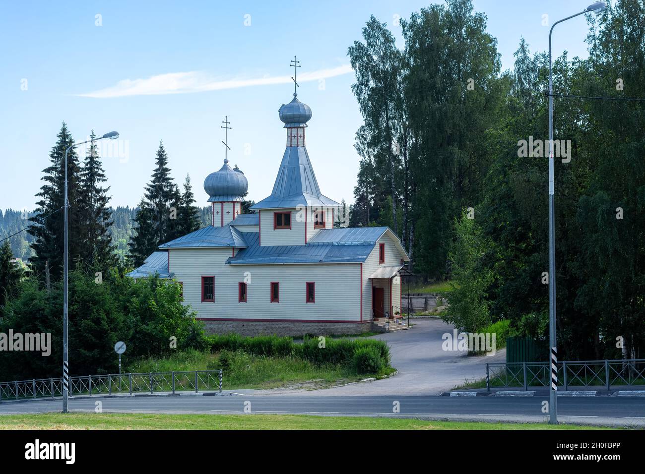 Orthodox wooden church by the road, surrounded by forest in the town of Lahdenpohya in Karelia. Stock Photo