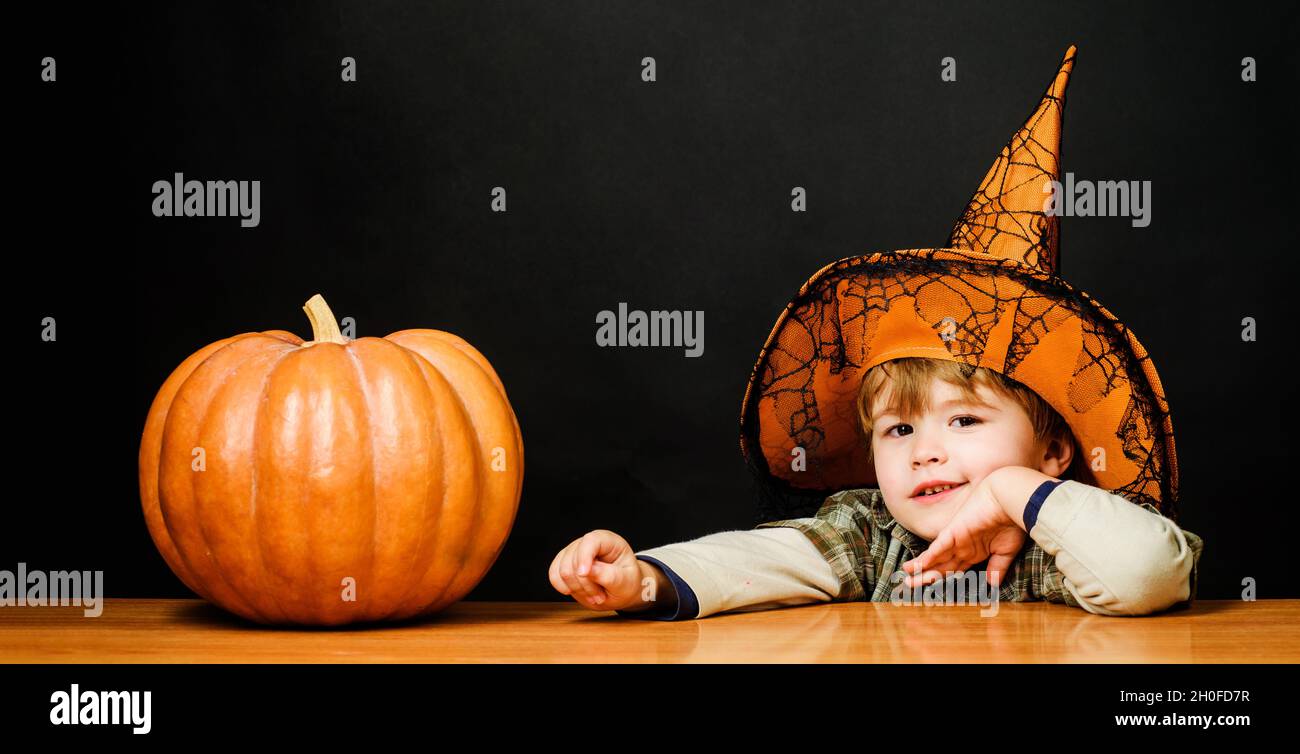 Preparation for Halloween party. Child in witch hat with halloween pumpkin. Witch costume. Autumn holidays. 31 October. Stock Photo