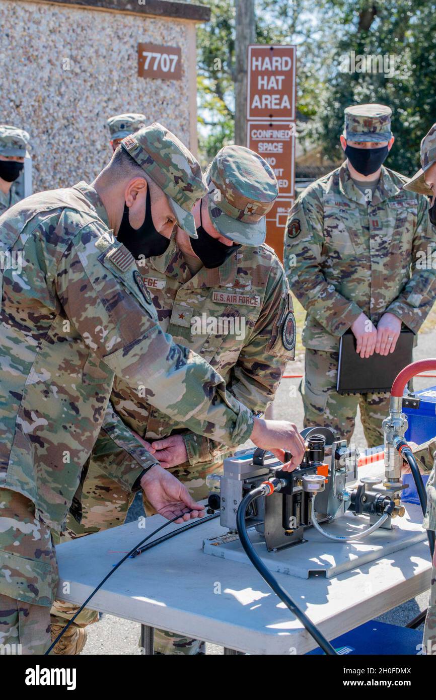 Brig. Gen. Chad Raduege and Col. Heather Blackwell 81st Training Wing Commander receive a jetted fiber demonstration from 85 EIS Cable and Antenna Systems technicians Staff Sgt. Eleazar Gutierrez and Senior Airman David Miranda, Feb. 24, 2021 at Keesler Air Force Base, Miss.     (by: U.S Air Force Capt. Nathan McWhirter) Stock Photo