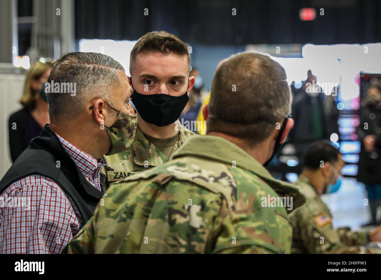 U.S. Army Staff Sgt. Trevor Zampese, 104th Brigade Engineer Battalion, center, talks to Brig. Gen. Jeffery P. Van, Joint Task Force-Civil Support (JTF-CS), left, duringa tour of the Middlesex County COVID-19 Vaccine Mega-Site in Edison, N.J., Feb. 26, 2021. New Jersey National Guard Soldiers and Airmen are assisting healthcare workers at six mega-sites statewide located in Atlantic, Bergen, Burlington, Gloucester, Middlesex, and Morris counties. Stock Photo