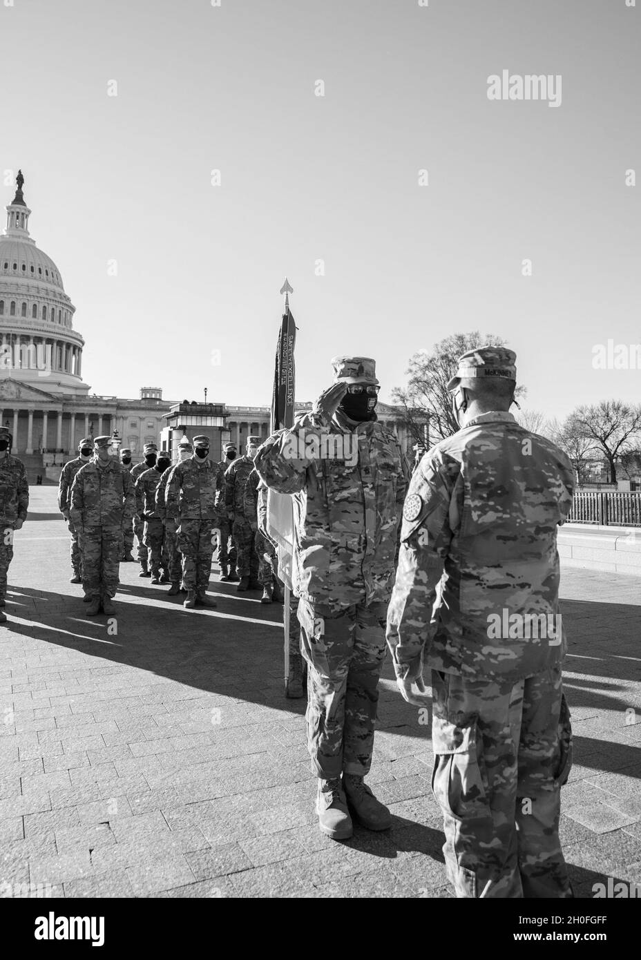 U.S. Army Command Sgt. Maj. William Russell III, senior enlisted advisor to the adjutant general, Michigan National Guard, salutes Col. Chirs McKinney, commander of the 177th Military Police Brigade, at the U.S. Capitol in Washington, D.C., Feb. 25, 2021. The National Guard has been requested to continue supporting federal law enforcement agencies with security, communications, medical evacuation, logistics, and safety support to state, district and federal agencies through mid-March. Stock Photo