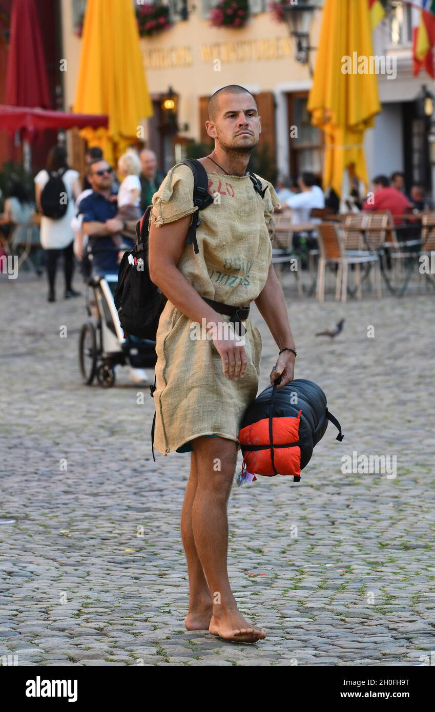 Man wearing sackcloth clothing on cobbled street in Freiburg