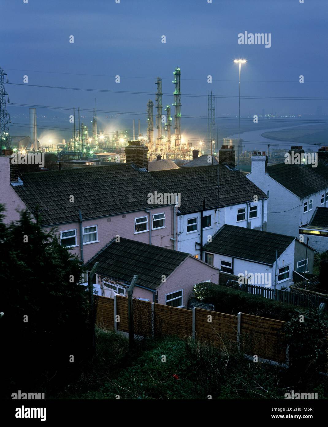 Housing next to solvent reactor towers at the former ICI chemical plant, Runcorn. Stock Photo