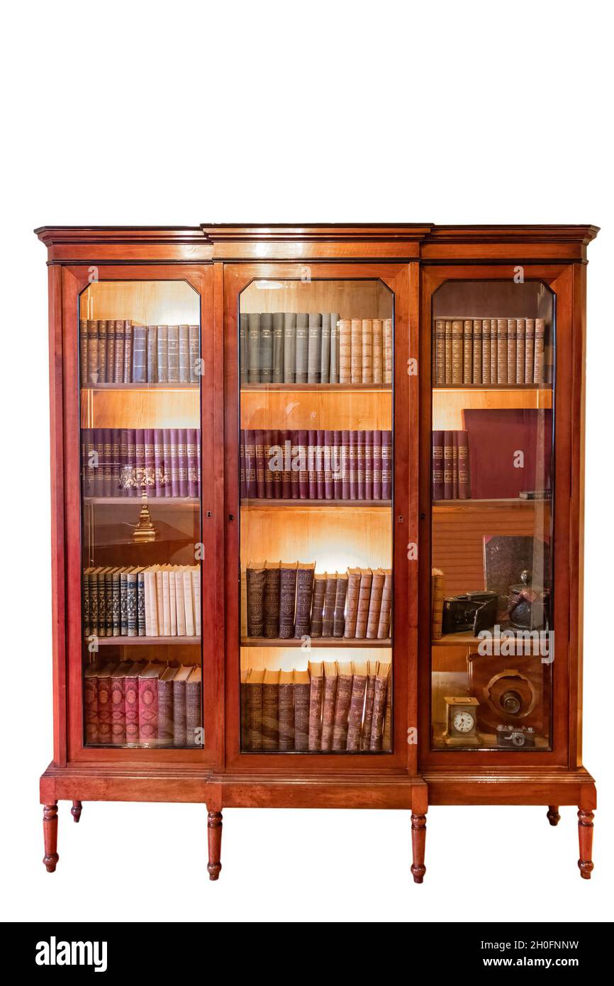 An old bookcase with books and glass doors isolated on white background Stock Photo