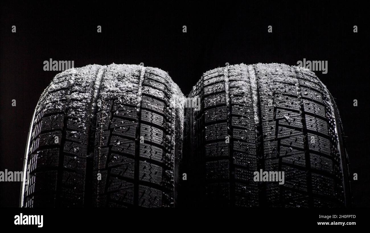 Winter Car tires with snow close-up wheel profile structure on black background.  Stock Photo