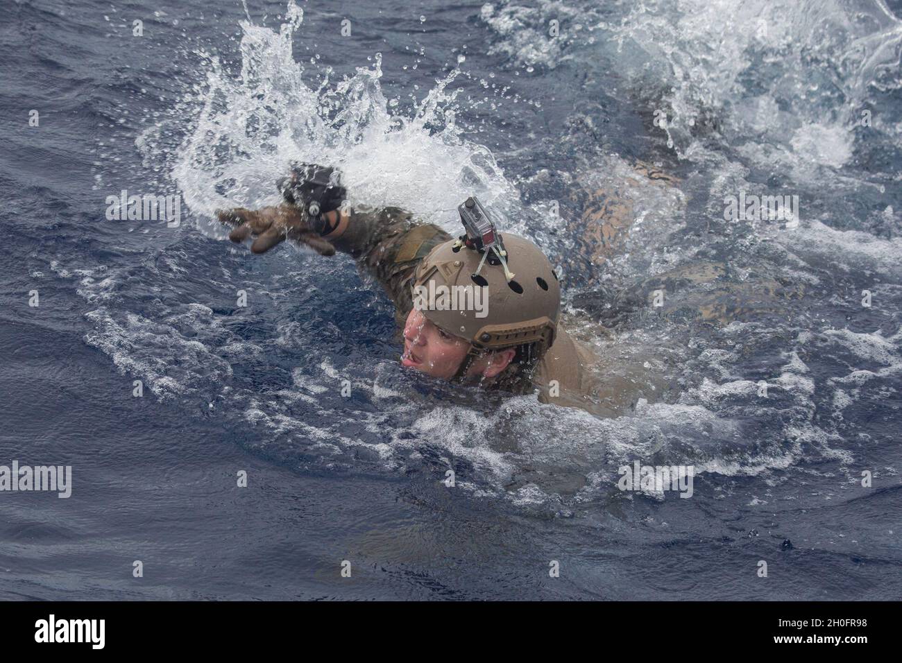 U.S. Navy Explosive Ordnance Disposal Technician 2nd Class Daniel Lemon, a native of Middletown, Connecticut, swims away from a simulated mine during mine countermeasure training in the Philippine Sea, Feb. 26, 2021. The 31st MEU is operating aboard ships of the Amphibious Squadron 11 in the 7th fleet area of operations to enhance interoperability with allies and partners and serve as a ready response force to defend peace and stability in the Indo-Pacific Region. Stock Photo