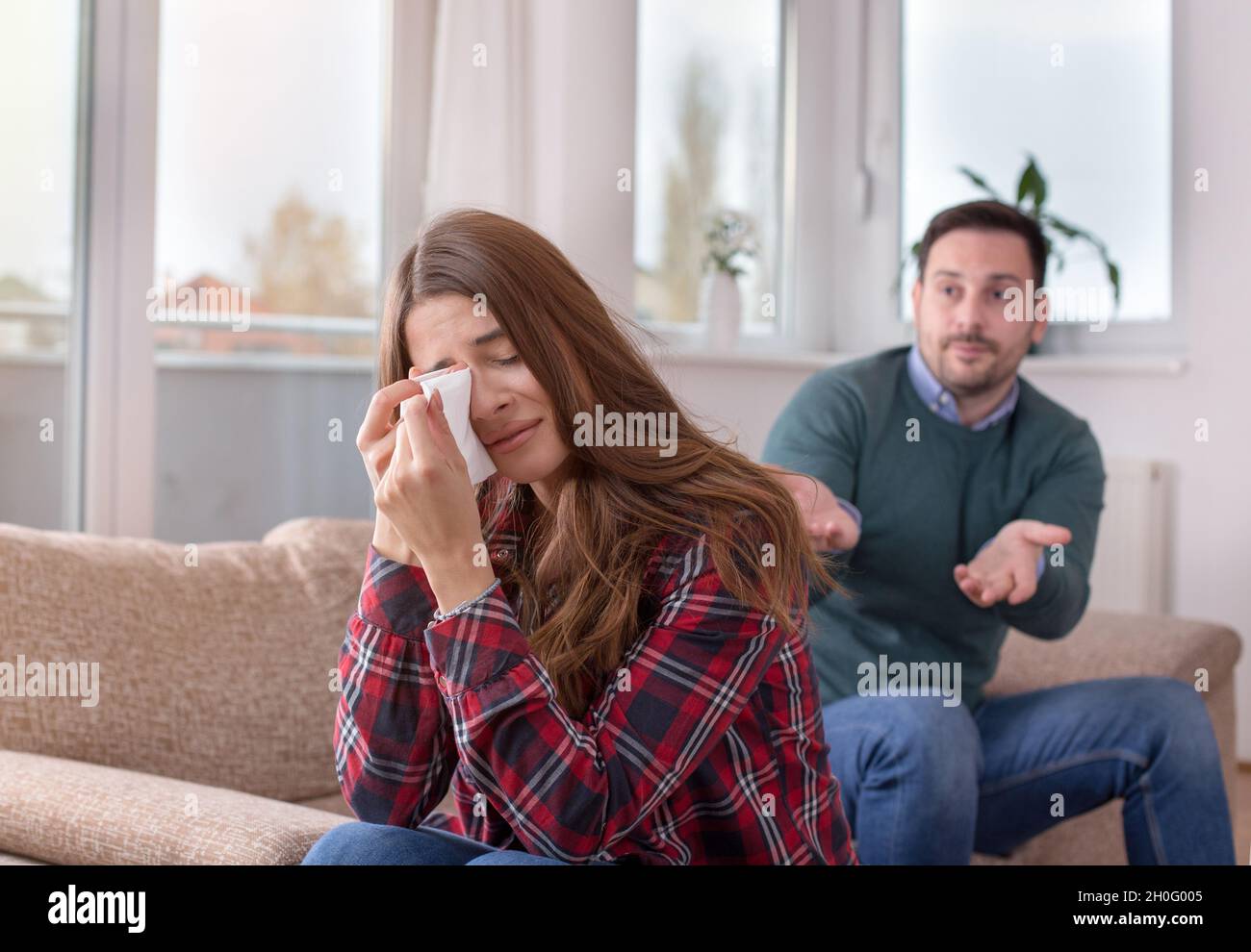 Young couple having fight at home. Girl crying man explaining something ...