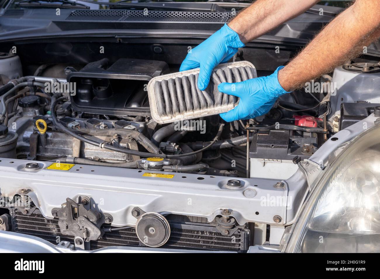 Auto mechanic holding used dirty internal combustion engine air filter for a car Stock Photo