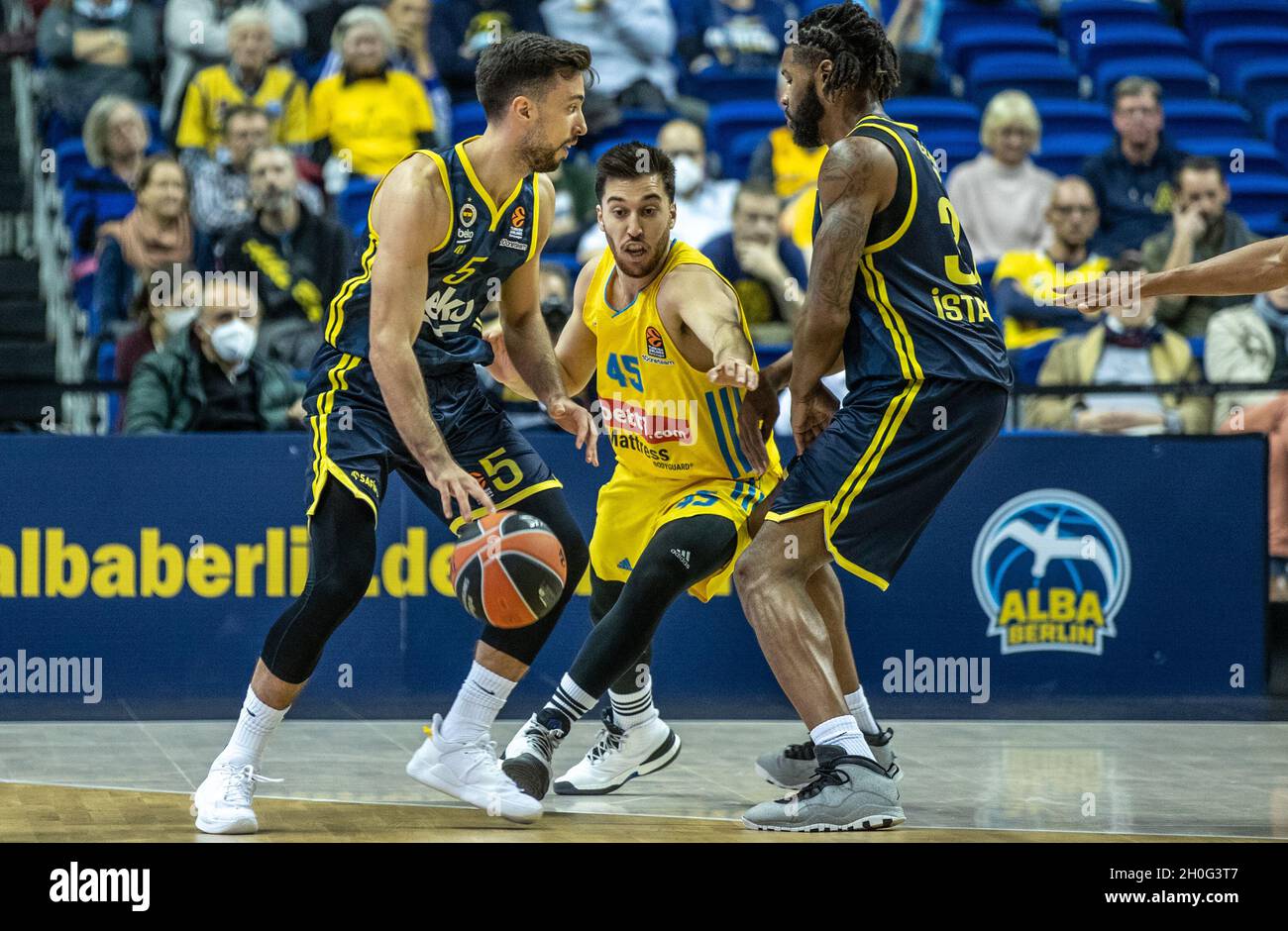 Berlin, Germany. 12th Oct, 2021. Basketball: Euroleague, Alba Berlin -  Fenerbahce Istanbul, Main Round, Matchday 3, Mercedes-Benz Arena. ALBA's  Tamir Blatt (M) is stopped by Ismet Akpinar (l) and Devin Booker of