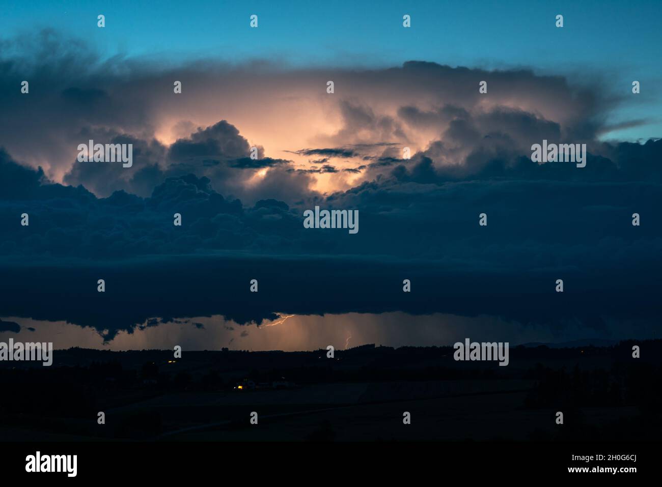 Dramatic looking lightning storm at the border of Austria and Germany during blue hour Stock Photo