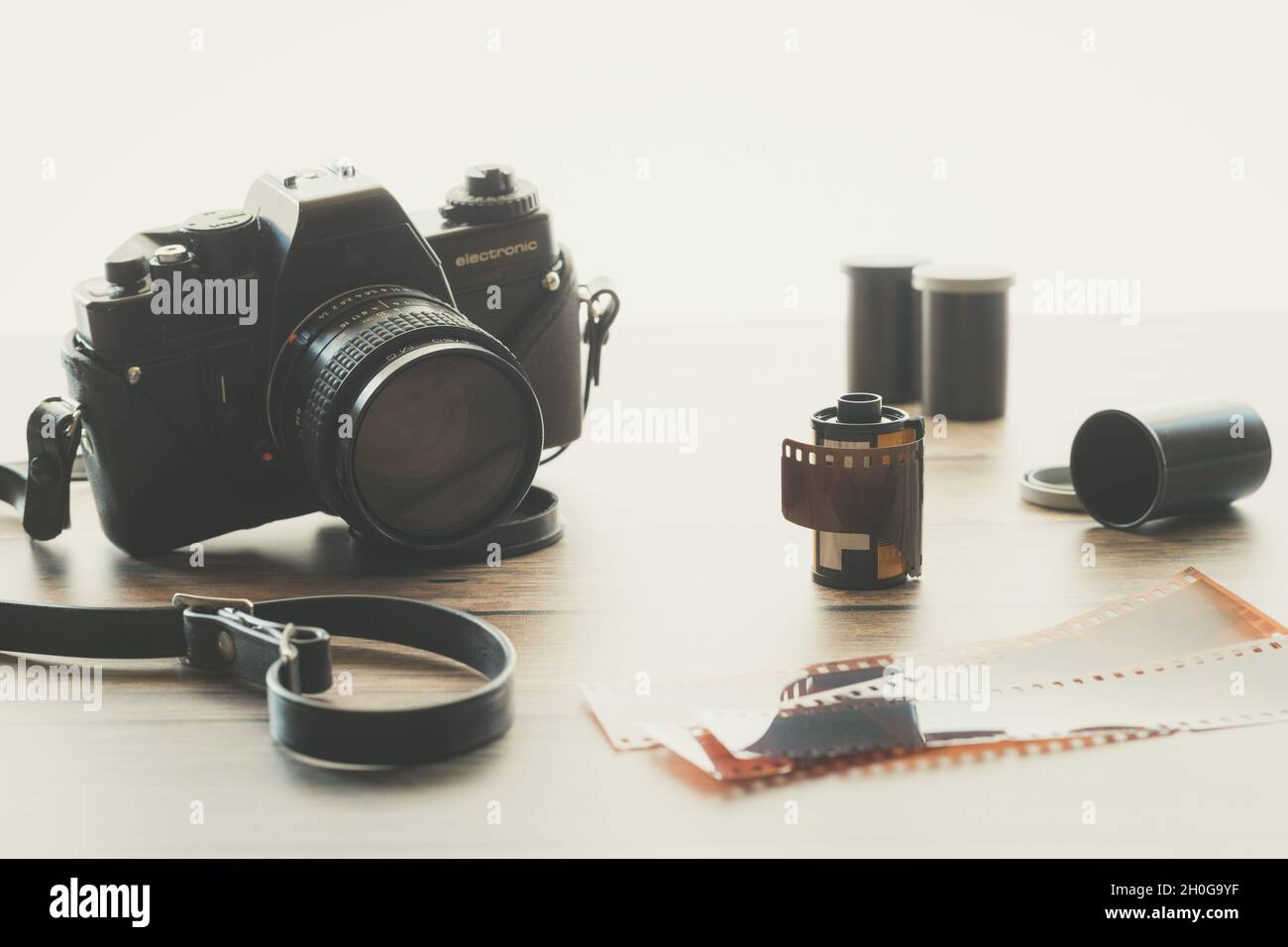 Vintage Film Camera with Filmstrip and Rolls of Film with Bright Background Stock Photo