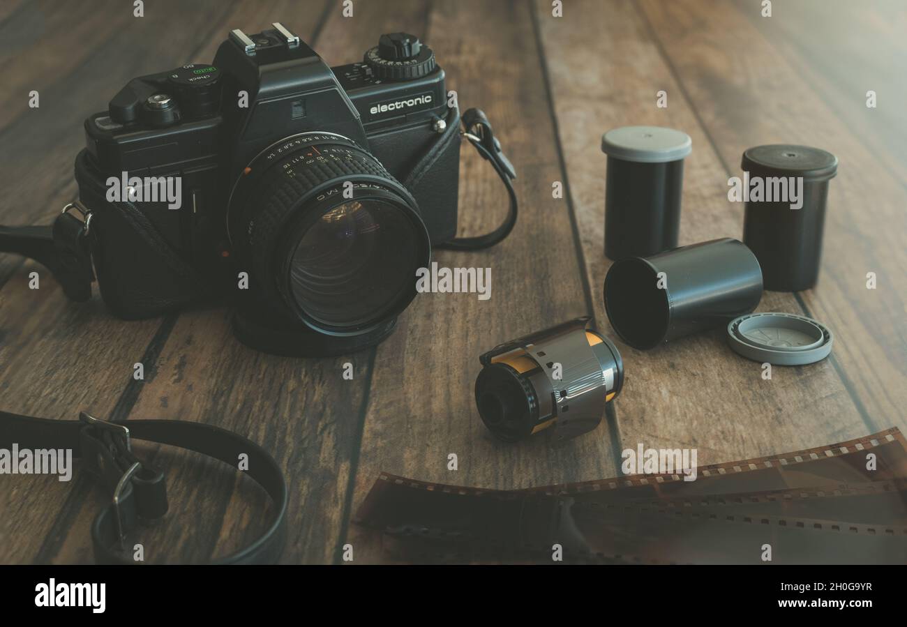 Closeup of Vintage Film Camera with Filmstrip and Rolls of Film Stock Photo