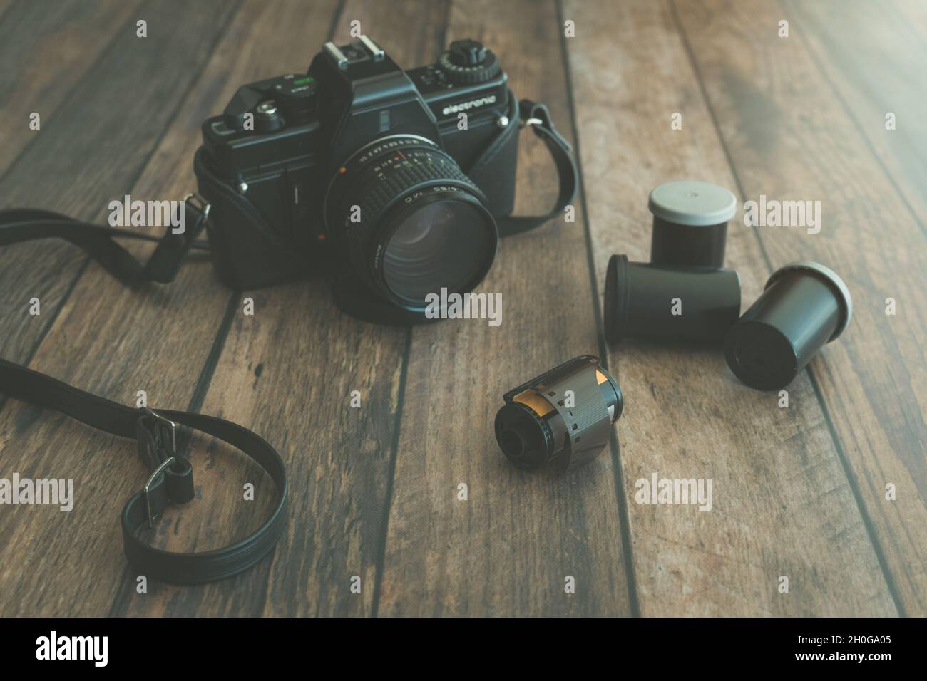 Vintage Film Camera with Rolls of Film on Wood Surface Stock Photo