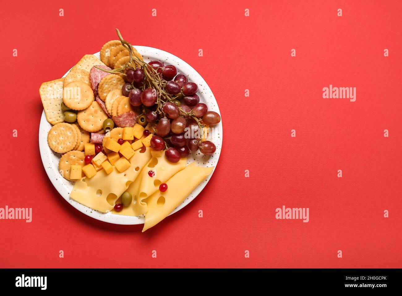 Platter with crunchy crackers and cheese on color background Stock