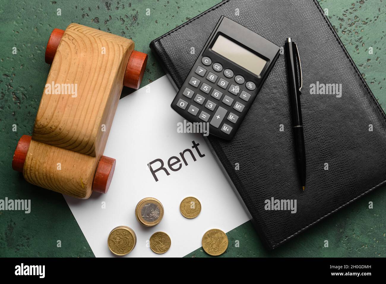 Background For Rent Paper Paper with word RENT, wooden car, coins and stationery on grunge ...