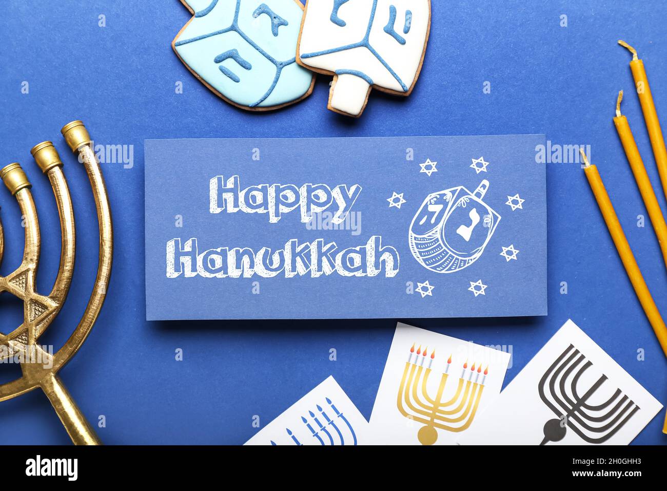 Different symbols of Hanukkah and greeting card on color background ...