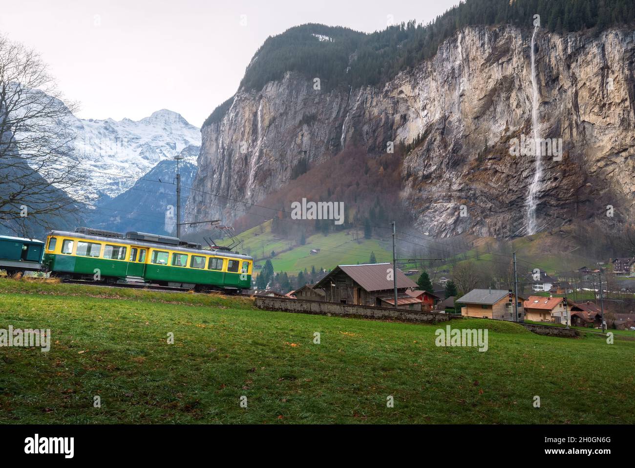 Train in Lauterbrunnen Valley with waterfalls on background - Lauterbrunnen, Switzerland Stock Photo