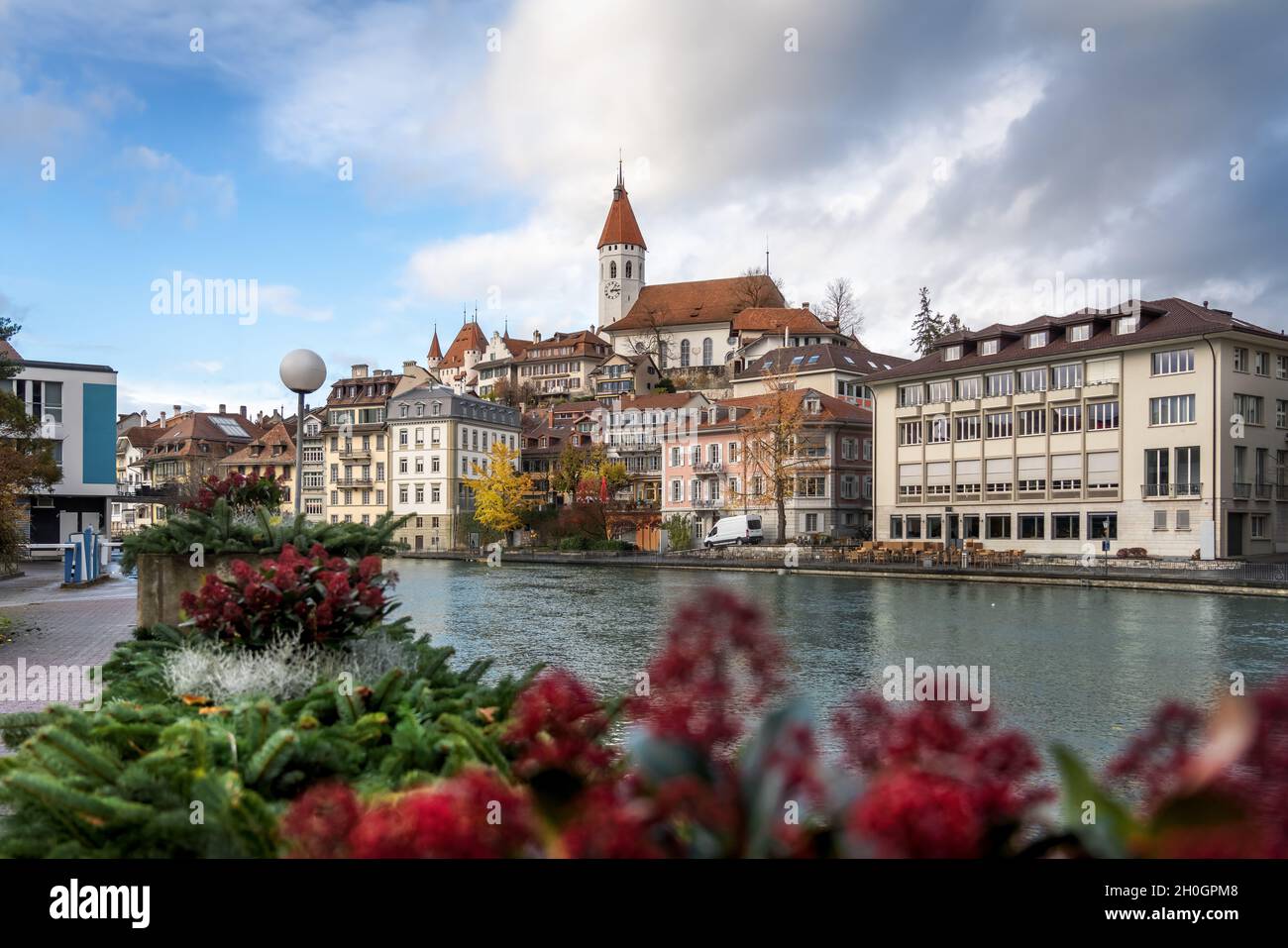 Colorful view of Aare river promenade and Thun Skyline with Thun City Church (Stadtkirche) and Thun Castle - Thun, Switzerland Stock Photo