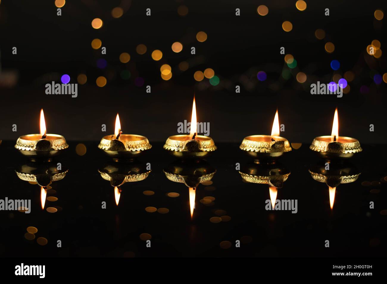Golden Brass Diya Illuminated With Reflection In Dark Black Background With Bokeh Effect. Indian Festival Theme For Diwali Pooja, Navratri, Dussehra P Stock Photo