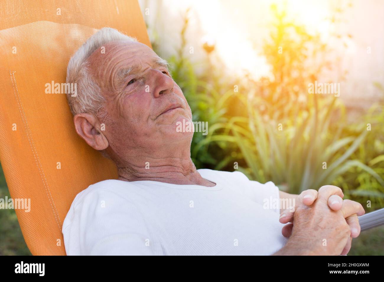 Old man resting on sunbed in garden. Depression in senior age Stock Photo Alamy