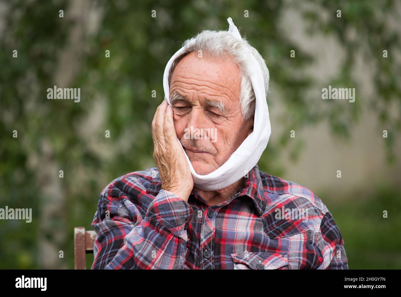 Old man having toothache, binding head with cold cloth Stock Photo Alamy