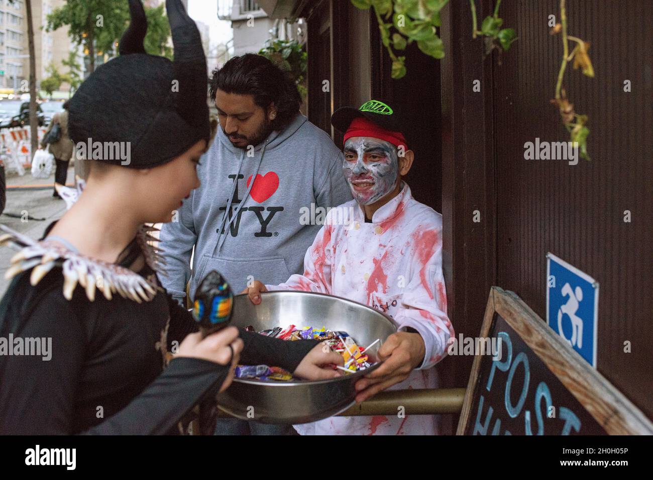 A neighborhood business giving out candy on Halloween in New York City. Stock Photo