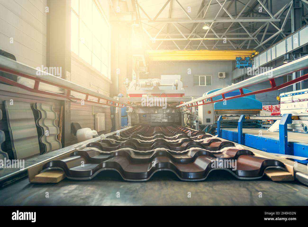 Metal roof tiles production line in metalwork factory. Stock Photo