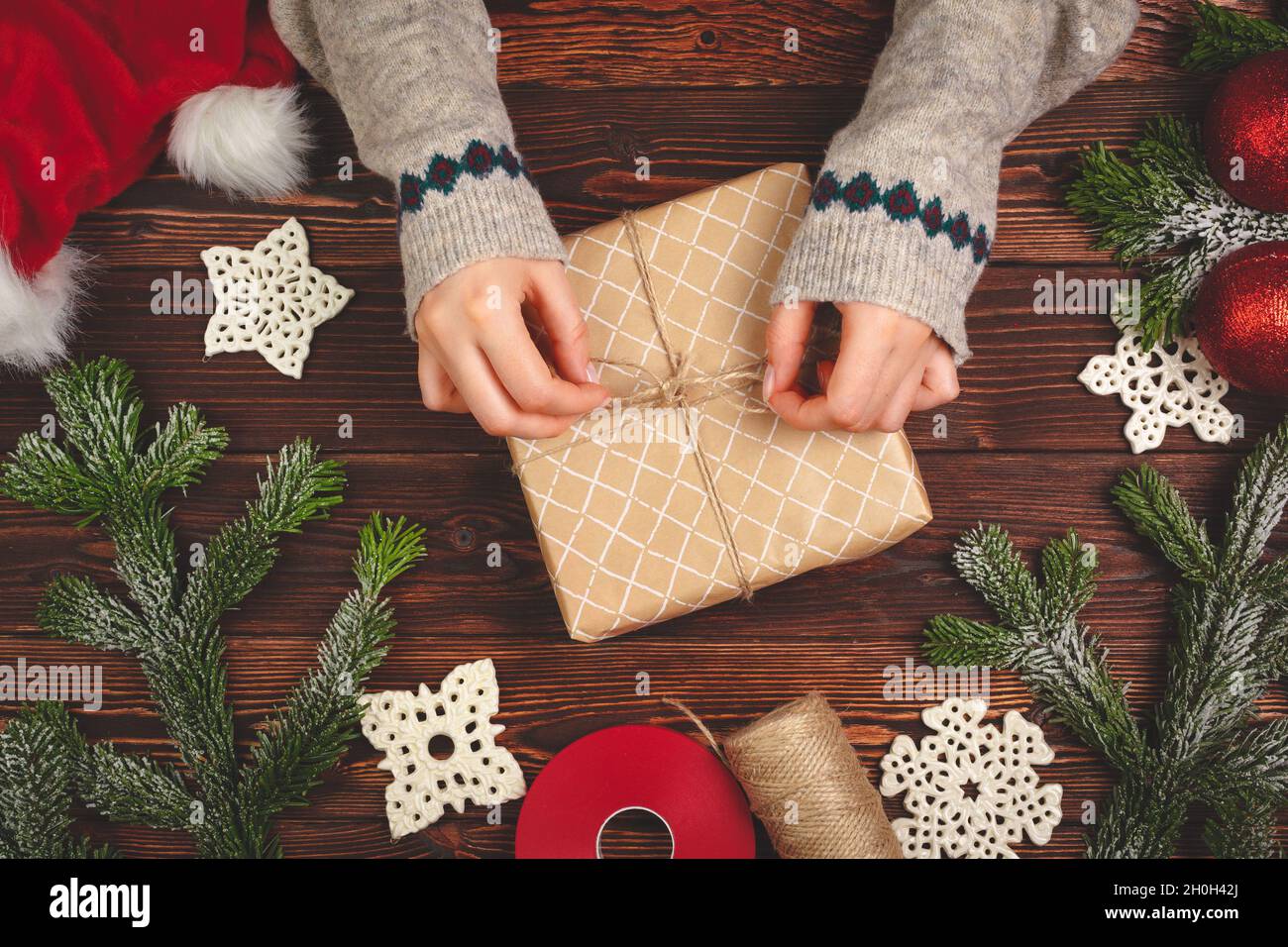 https://c8.alamy.com/comp/2H0H42J/top-view-of-a-woman-hands-with-a-christmas-gift-on-wooden-background-2H0H42J.jpg