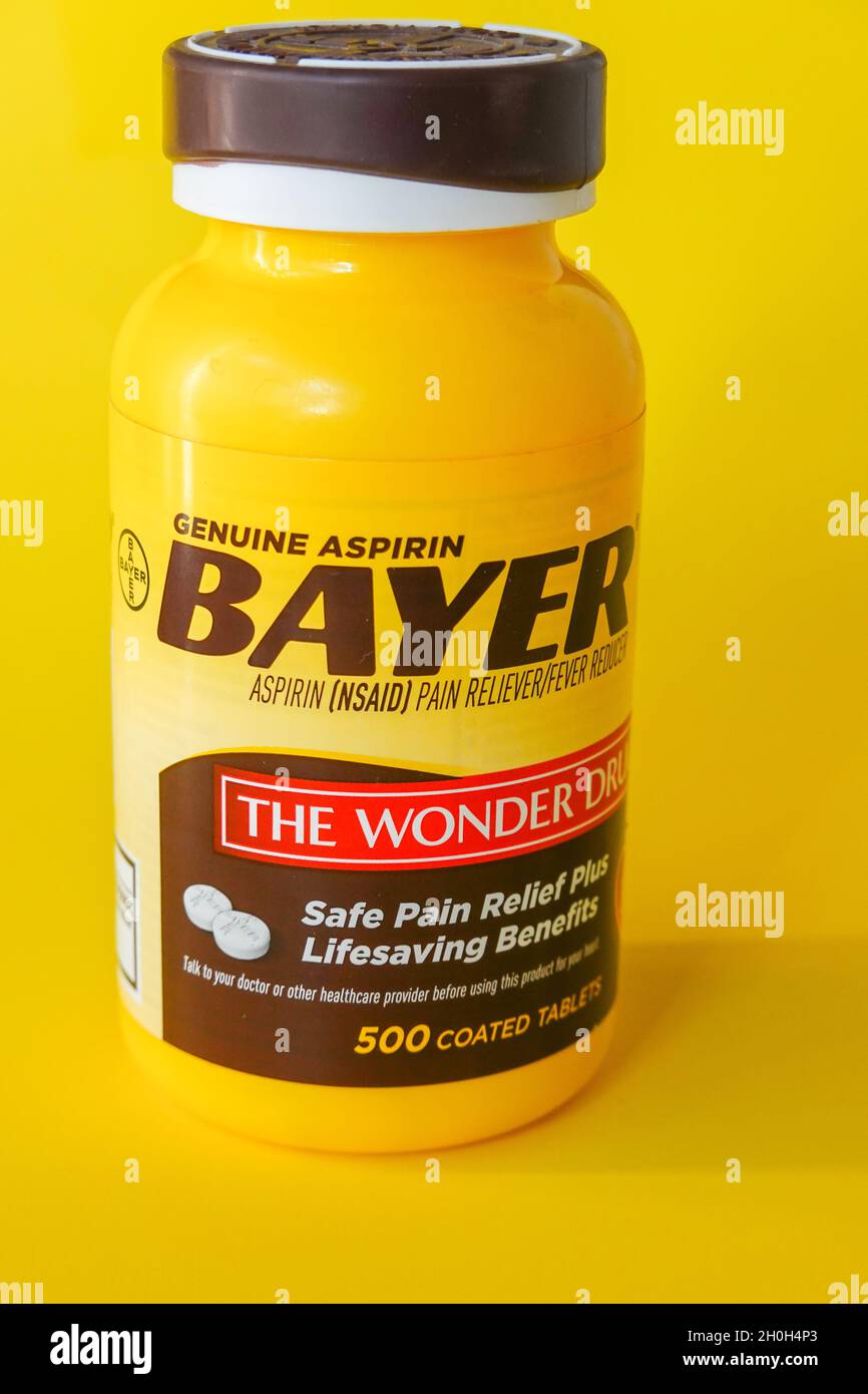 Bayer aspirin tablet container against a yellow background Stock Photo Alamy
