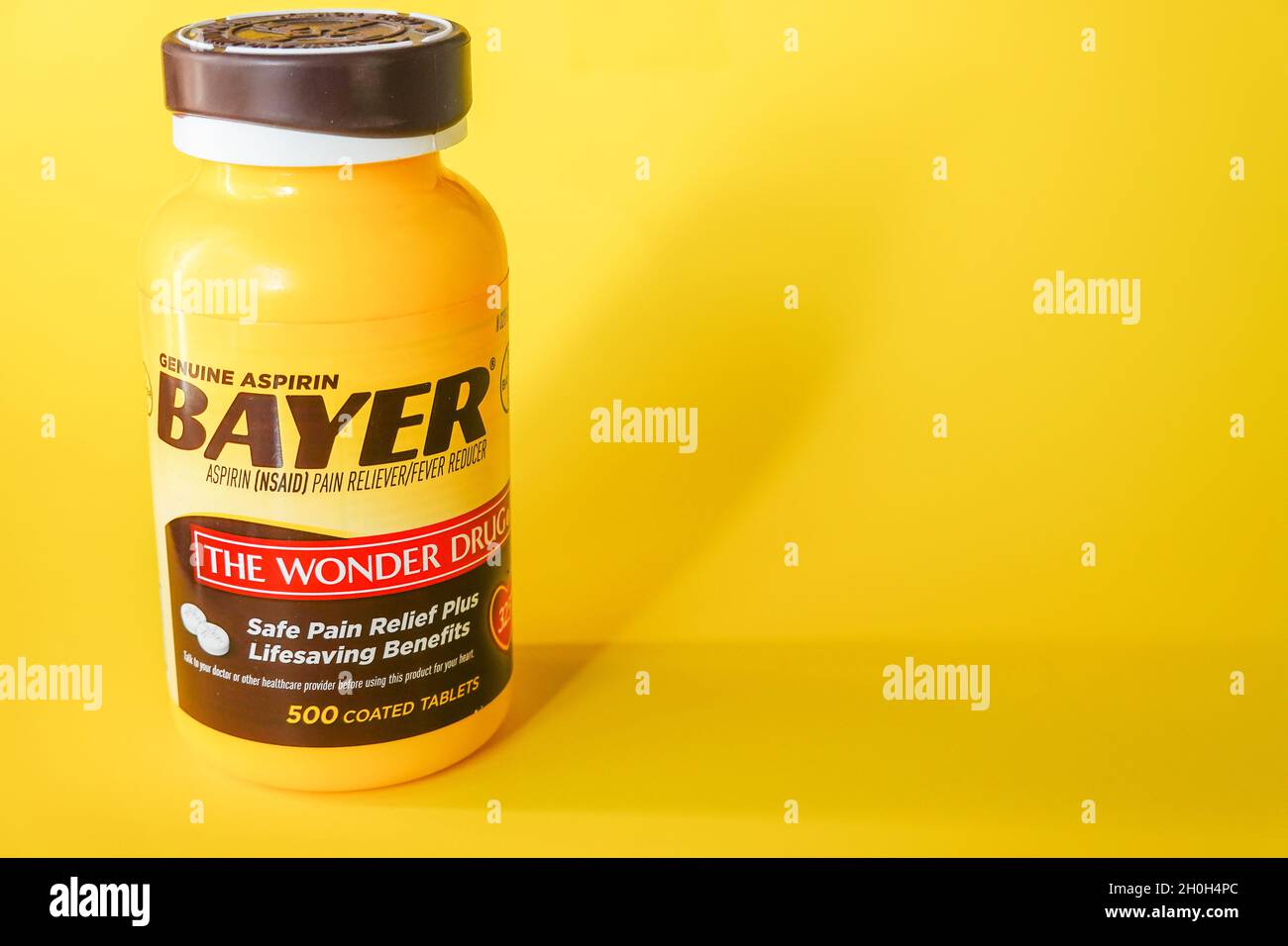 Bayer aspirin tablet container against a yellow background Stock Photo Alamy