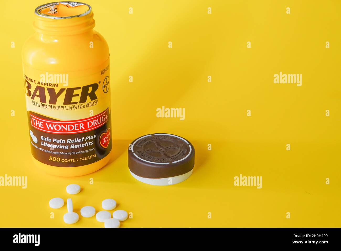 Bayer aspirin tablet container against a yellow background Stock Photo Alamy