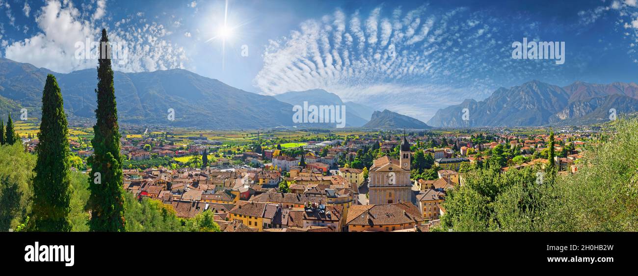 Old idyllic town surrounded by mountains with the Collegiata dell'Assunta church and fascinating sky, Castello di Arco, Arco, Valle de Sarco, Lake Stock Photo