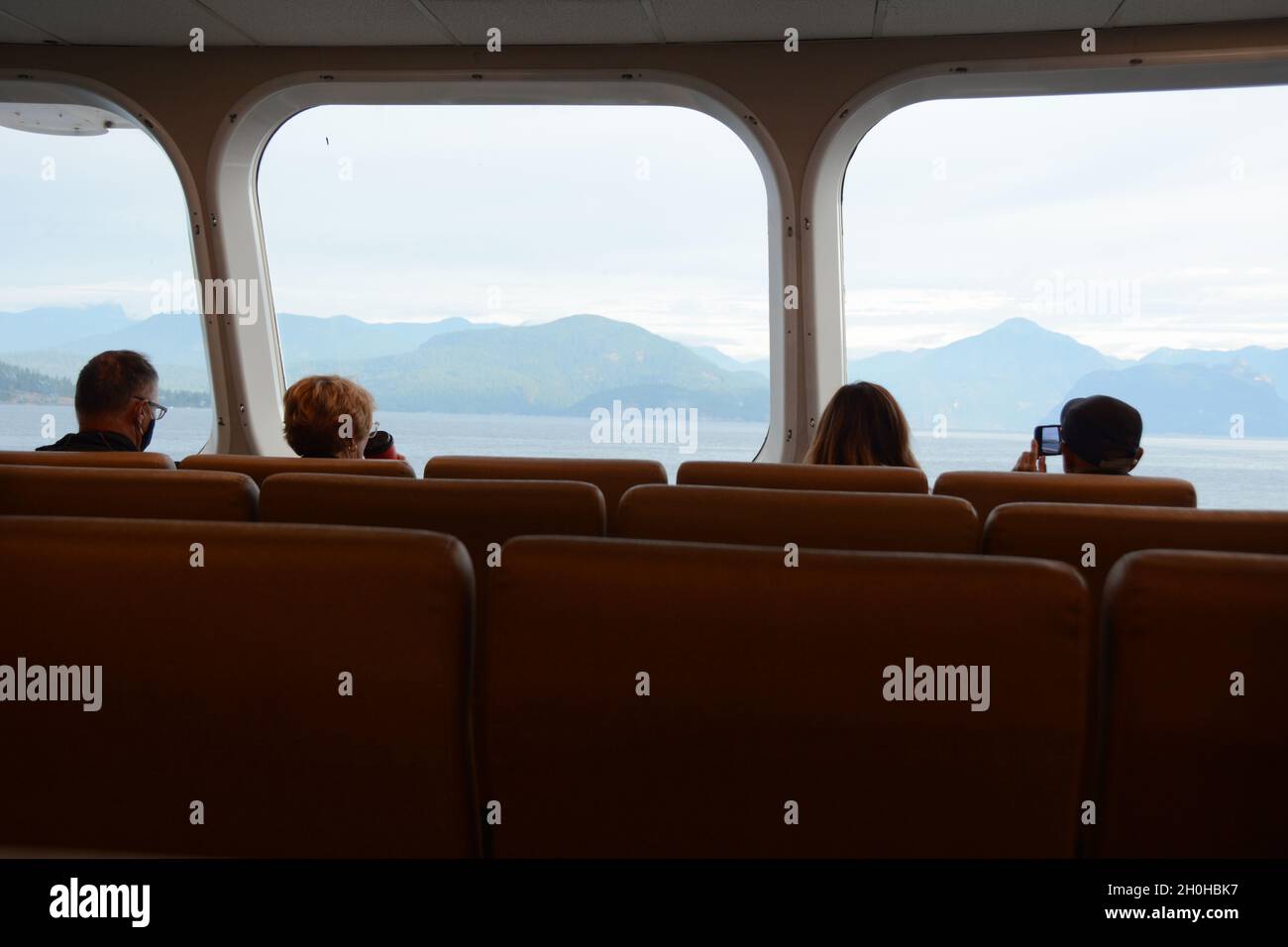 Passengers seated inside of a BC Ferry boat sailing between Horseshoe