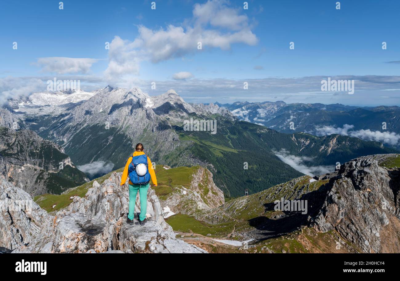 Hiker on a summit, Westliche Toerlspitze, mountains in dramatic clouds, Zugspitze in the back, Wetterstein Mountains, Garmisch-Partenkirchen Stock Photo