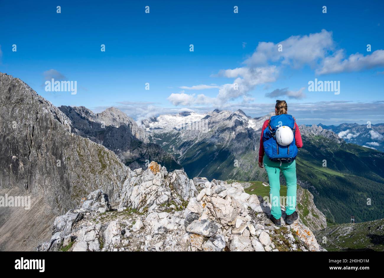 Hiker on a summit, Westliche Toerlspitze, mountains in dramatic clouds, middle Zugspitze, Wetterstein Mountains, Garmisch-Partenkirchen, Bavaria Stock Photo