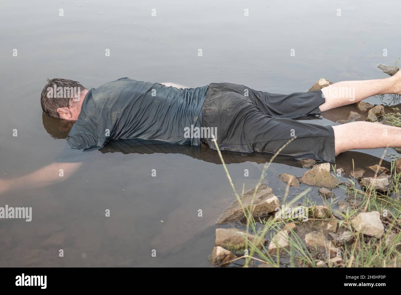 the-body-of-a-man-who-drowned-lying-face-down-in-the-water-lifeless-body-artistic-photo-painting-selective-focus-2H0HF0P.jpg