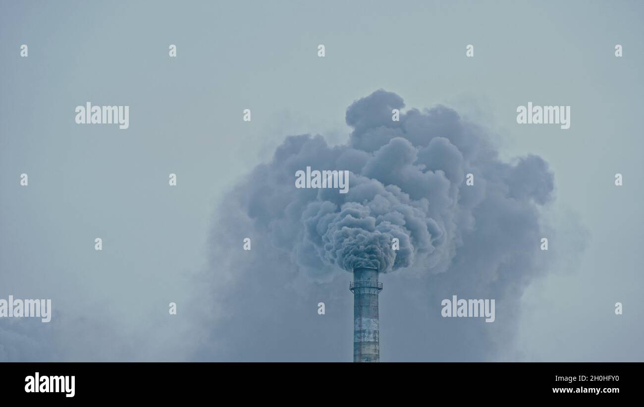 This smoke coming from the chimney in a factory. Harmful emissions into the atmosphere, from the pipe. Serious damage the environment. Stock Photo