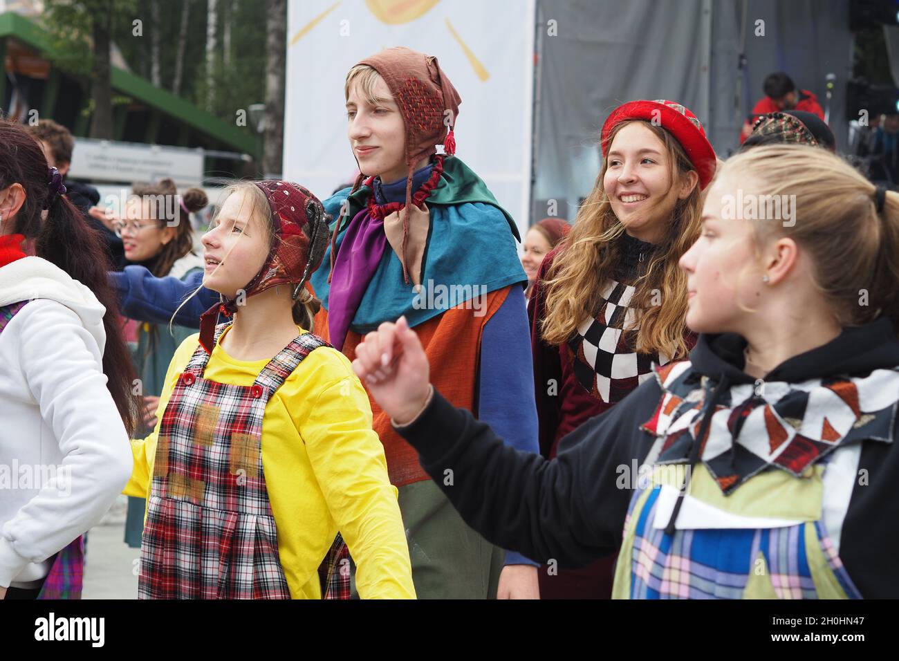 People, children, teenagers in colorful costumes have fun and dance on ...