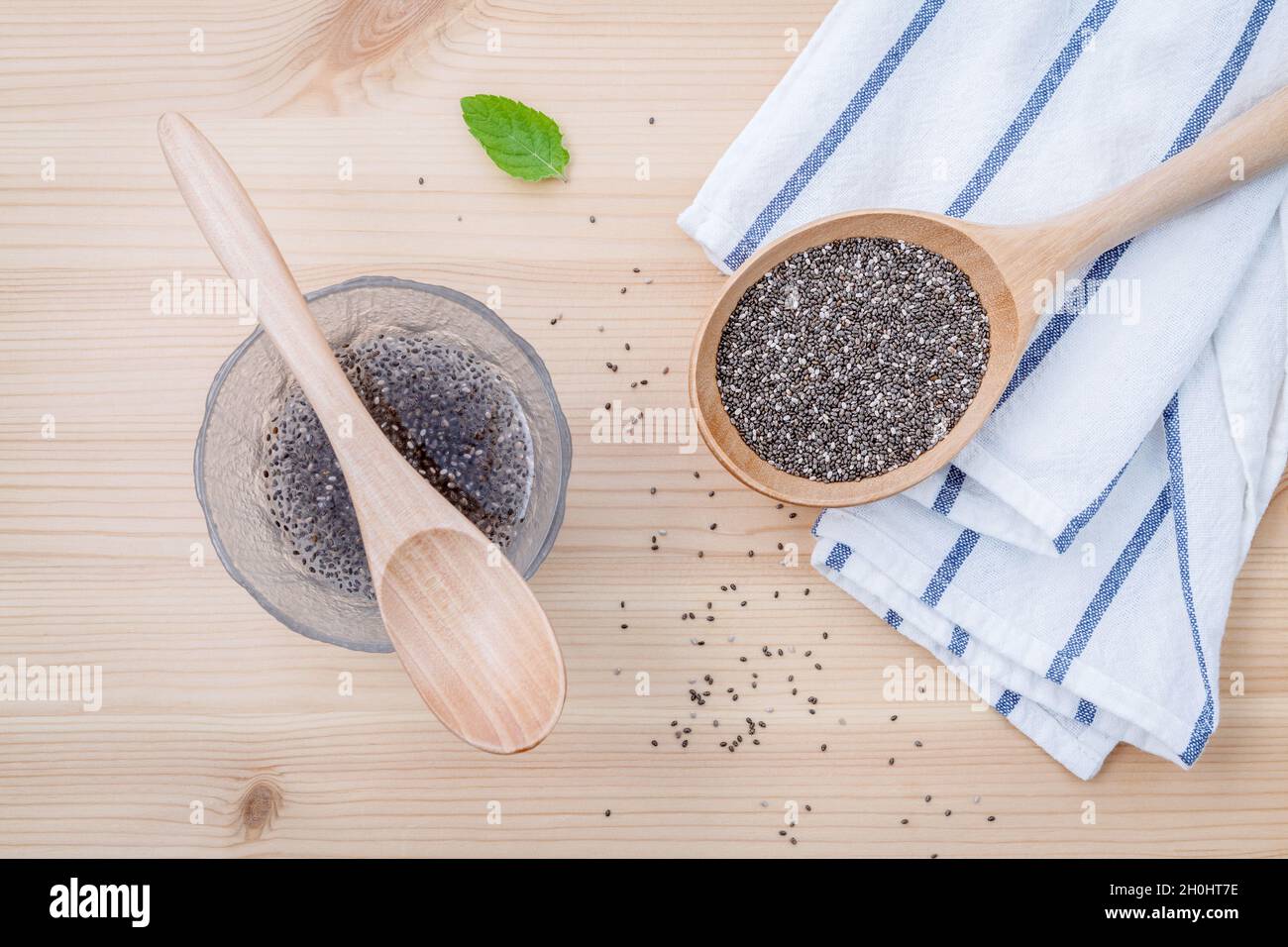 Nutritious chia seeds in glass bowl with wooden spoon for diet food ingredients setup on wooden background . shallow depth of field. Stock Photo