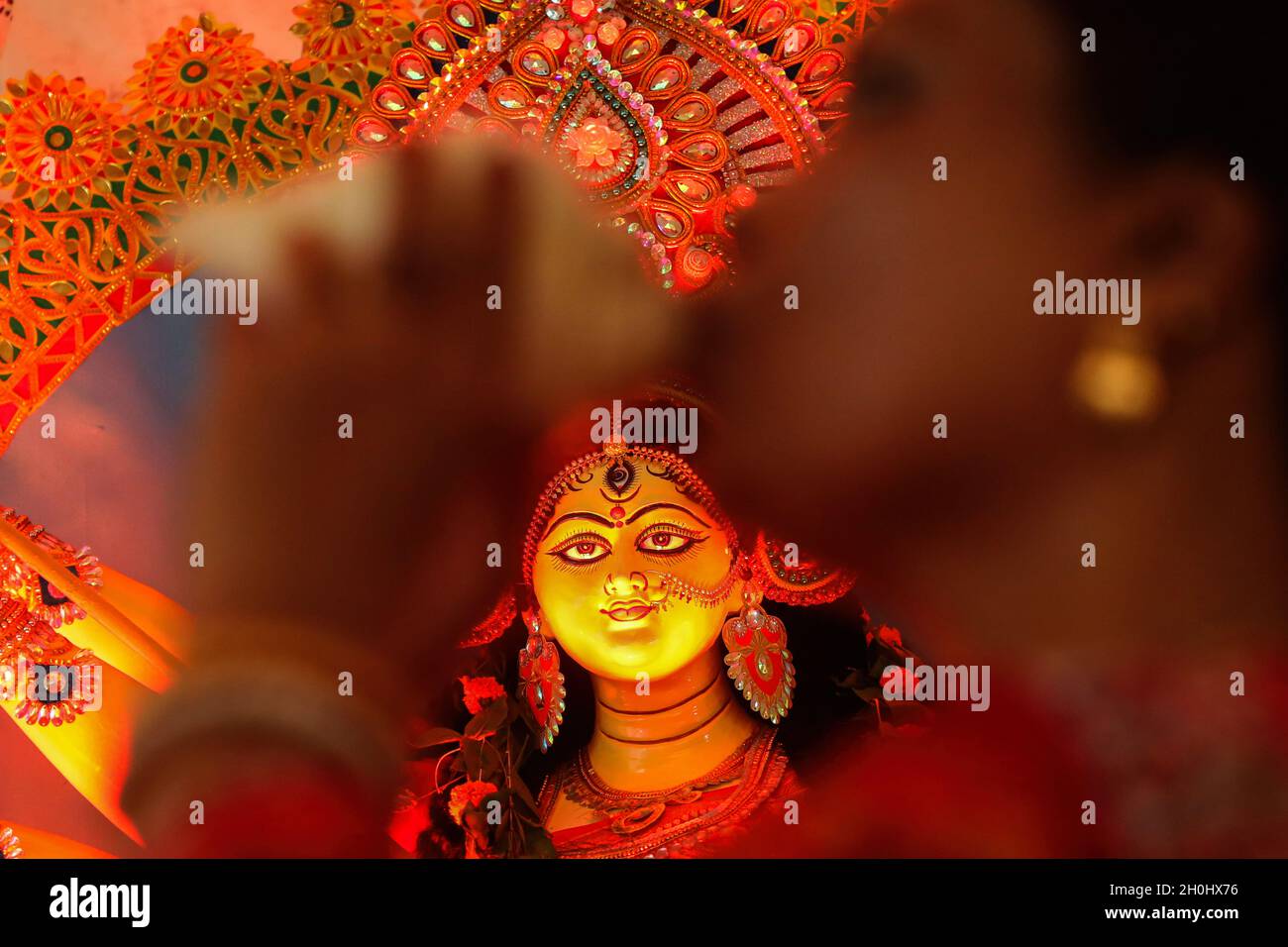Dhaka, Bangladesh. 12th Oct, 2021. Hindu Devotee seen blowing conch shells amid the idol of Goddess Durga seen on the background during the festival.7th day of Durga puja festival known as Saptami, the biggest Hindu festival running for 9 days all over Bangladesh. Credit: SOPA Images Limited/Alamy Live News Stock Photo