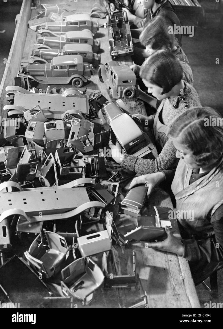 Workers assembling cars from previously bent sheet metal parts in a toy