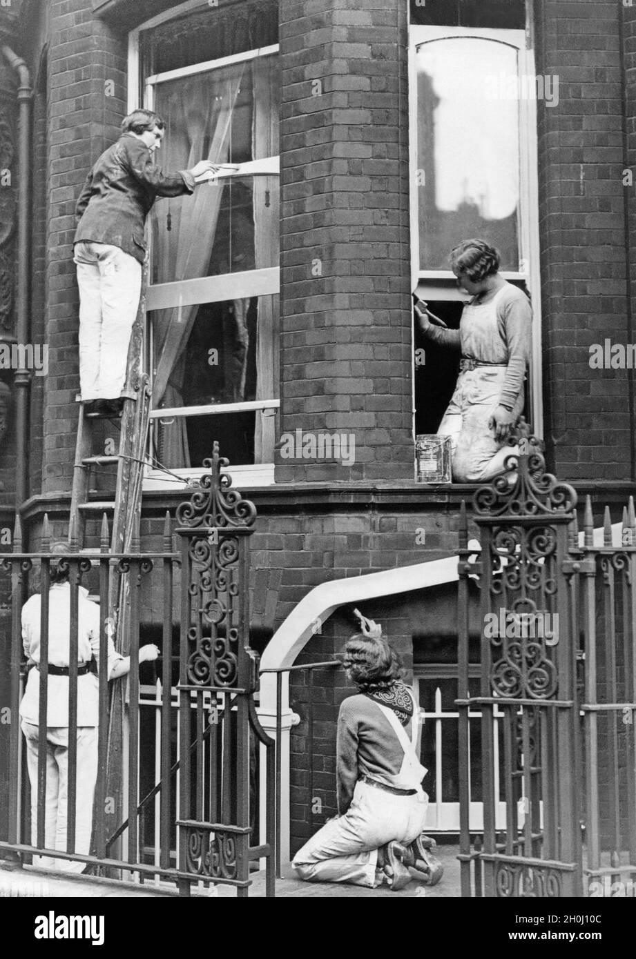 Elizabeth McNabb (left, above), daughter of Surgeon Rear Admiral Sir Daniel McNabb, paints the shutters of a house in Dreycot Place in the Chelsea district of London, with Margaret Dodds and two of her pupils. [automated translation] Stock Photo