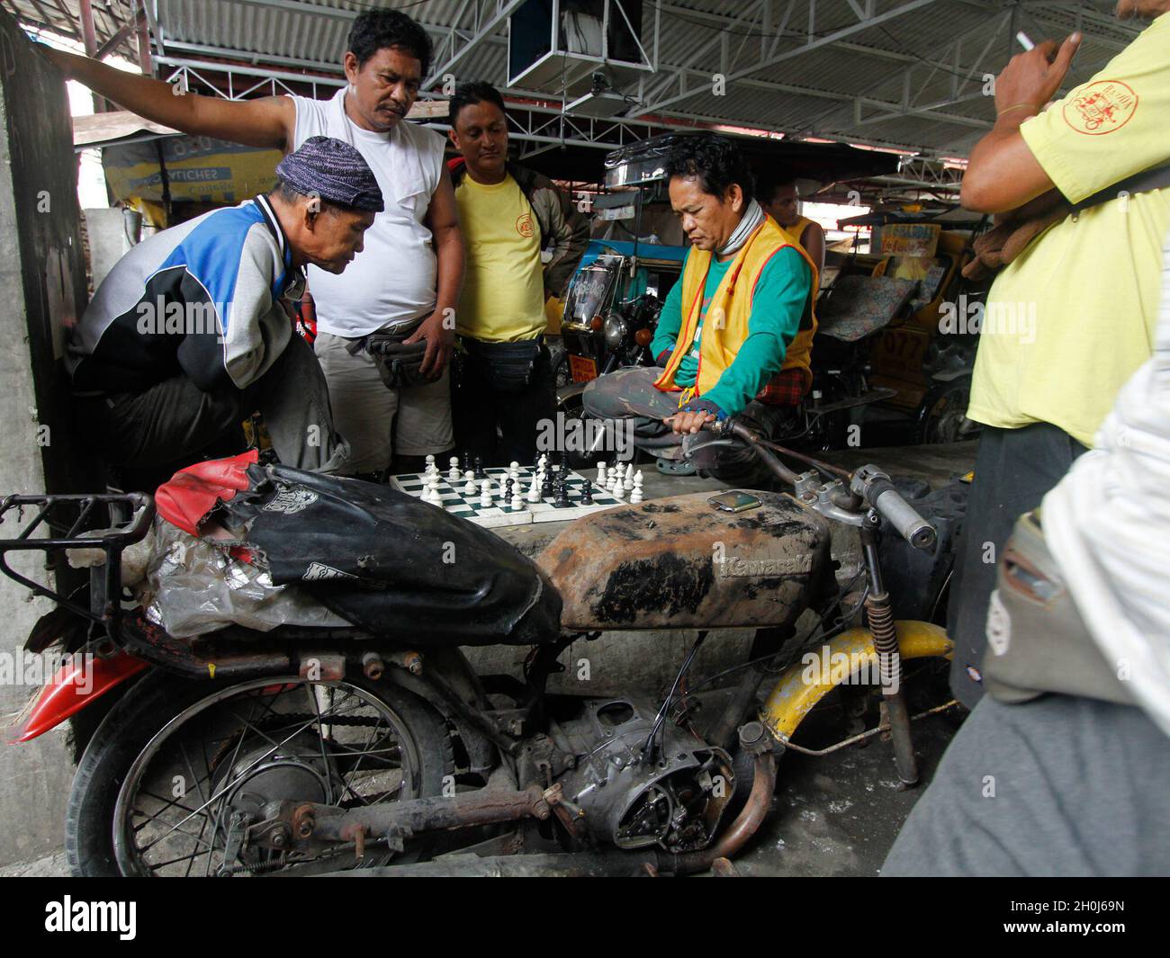 Tricycle drivers play chess inside their waiting area in Batasan Hills